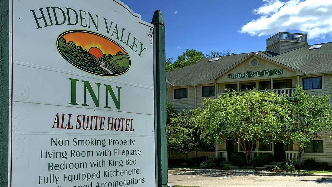 Exterior of the Hidden Vally Inn sign in the foreground with the inn in the background