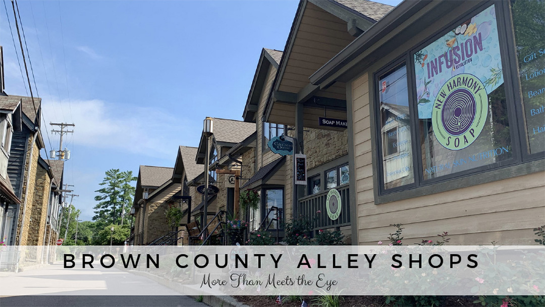 Exterior of store fronts lining an alley with text at the bottom that reads "Brown County Alley Shops, More Than Meets the Eye"