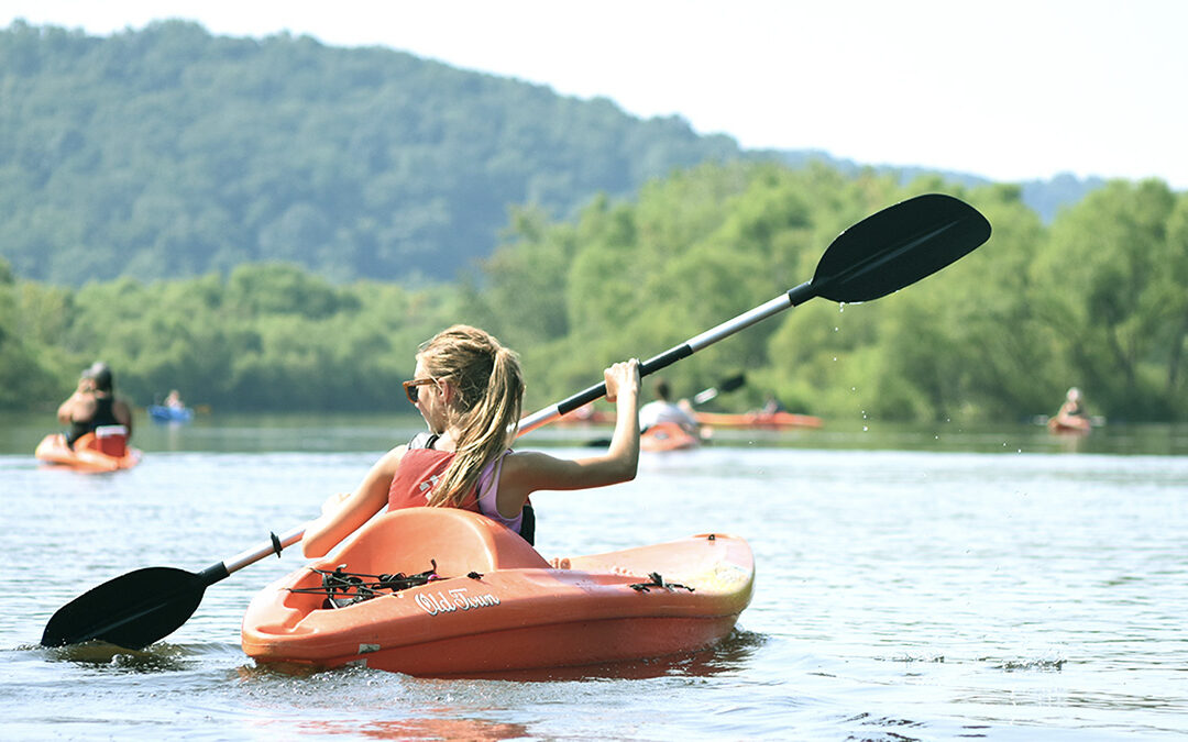 Young girl kayaks on a lake