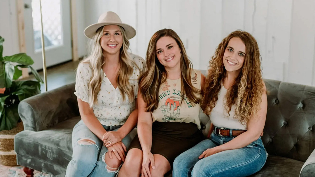 Business portrait of three young women sitting on a couch in casual attire