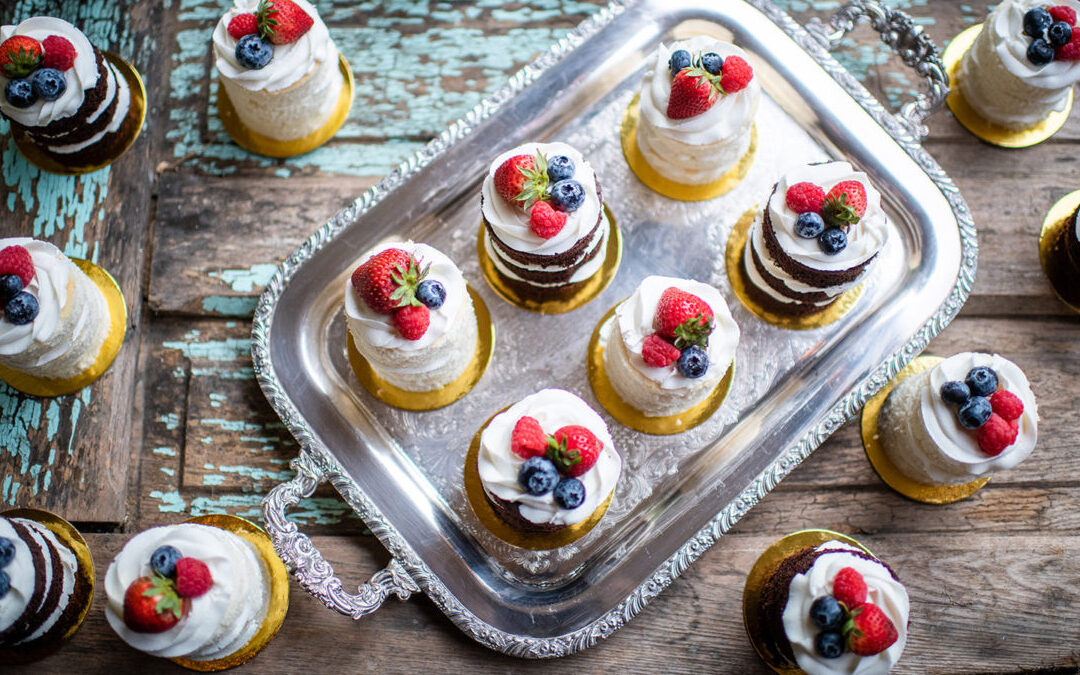 A tray of wedding deserts with berries on top from above