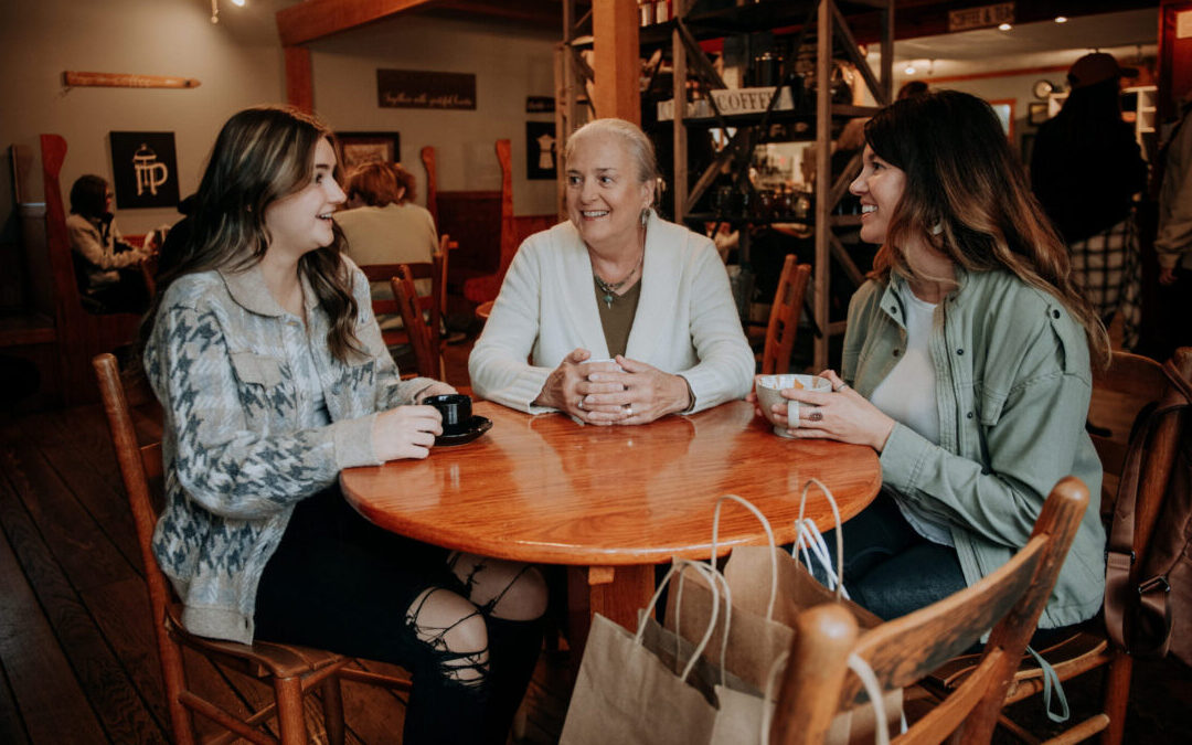 Three women sitting at a table and drinking coffee