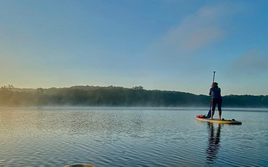 Paddle boarder on a calm lake